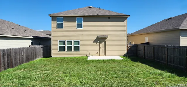 a front view of a house with yard and wooden fence