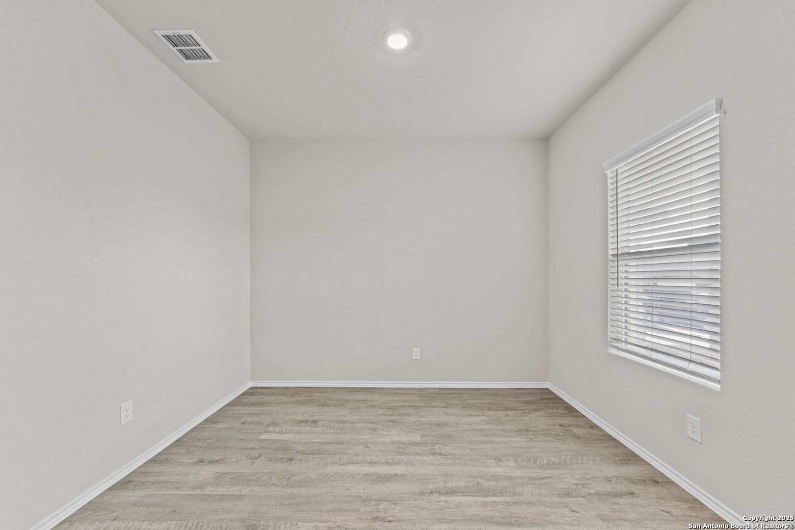 7115 Mesa Cliffs Converse, TX 78109 - Photo 6 of 30 a view of an empty room with wooden floor and a window