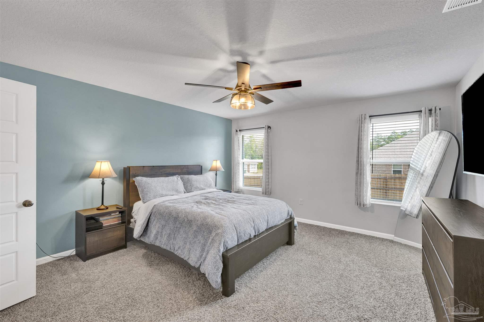 9747 MilleeLoop Loop Pensacola, FL 32526 - Photo 13 of 31 a bedroom with a bed a window and a chandelier