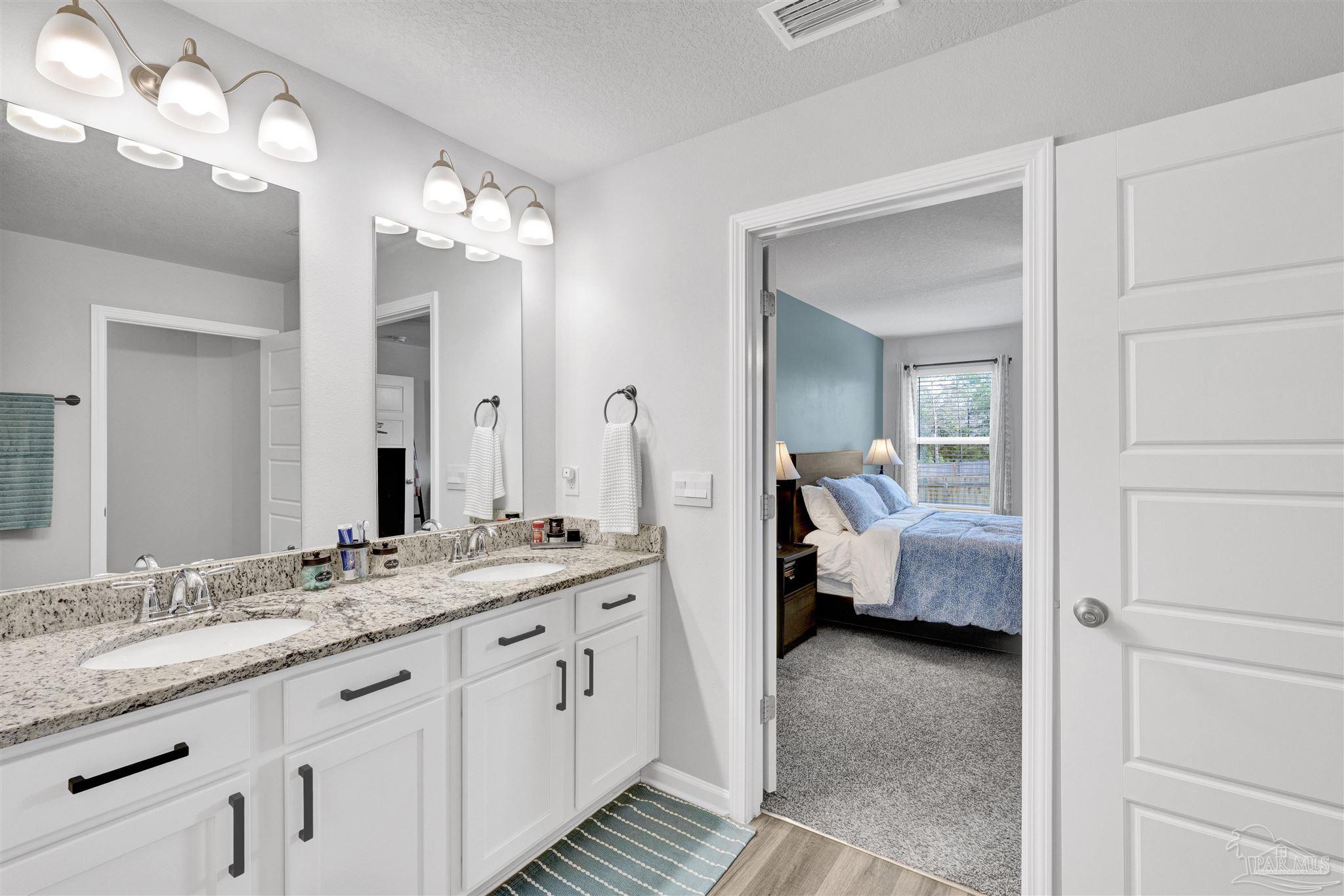 9747 MilleeLoop Loop Pensacola, FL 32526 - Photo 14 of 31 a en suite bathroom with a double vanity sink and a mirror