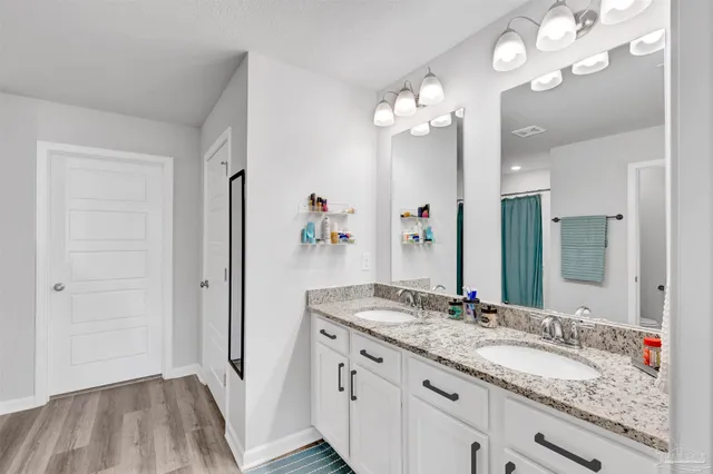 a bathroom with a granite countertop sink a large mirror and a shower