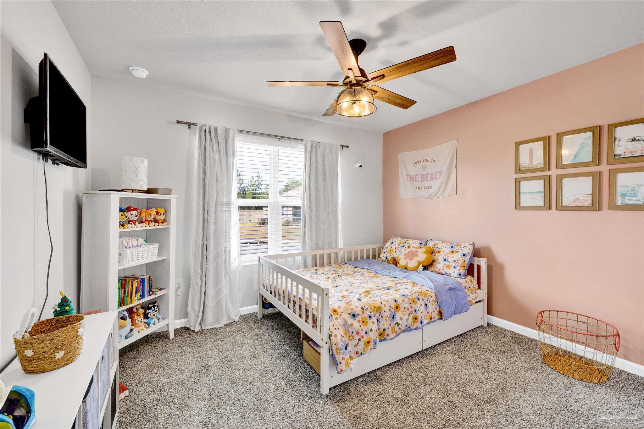 9747 MilleeLoop Loop Pensacola, FL 32526 - Photo 17 of 31 a bedroom with a bed a flat screen tv and a window