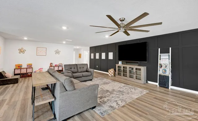 a living room with furniture and a flat screen tv with wooden floor