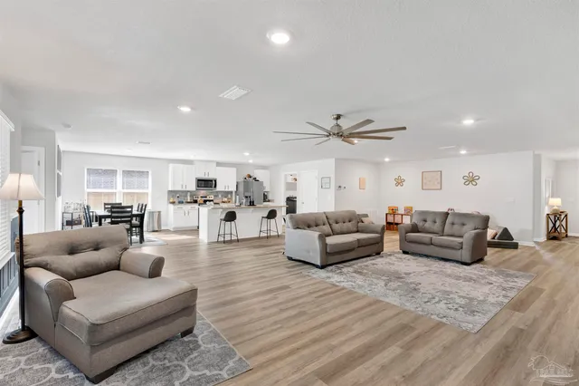 a living room with furniture and view of kitchen