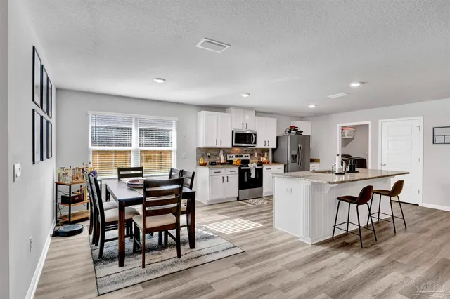 a kitchen with sink a table and chairs