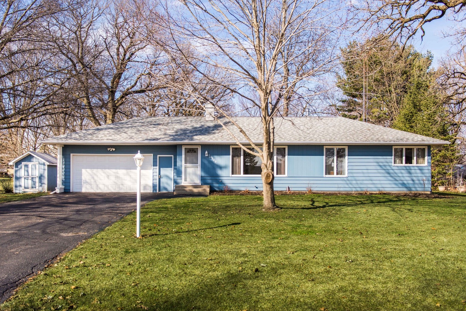 13369 Ash Road Genoa, IL 60135 - Photo 25 of 26 a front view of a house with a garden and trees