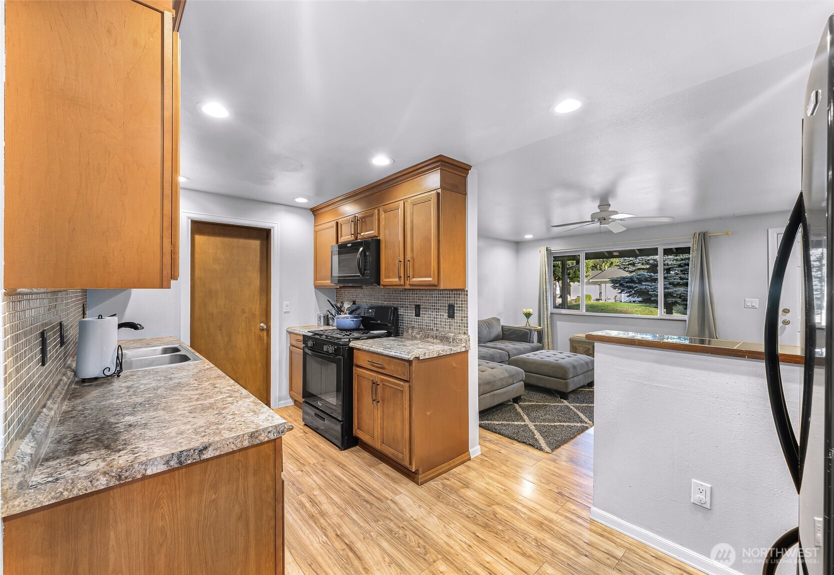 205 Cashmere Lane Everson, WA 98247 - Photo 15 of 40 a kitchen with stainless steel appliances granite countertop a stove top oven a sink dishwasher and wooden cabinets with wooden floor