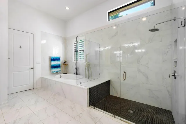 a bathroom with a tub sink shower and mirror