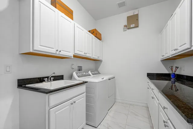 a kitchen with stainless steel appliances granite countertop a sink and dishwasher with white cabinets