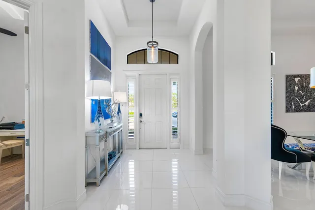 a hallway with cabinets and chandelier