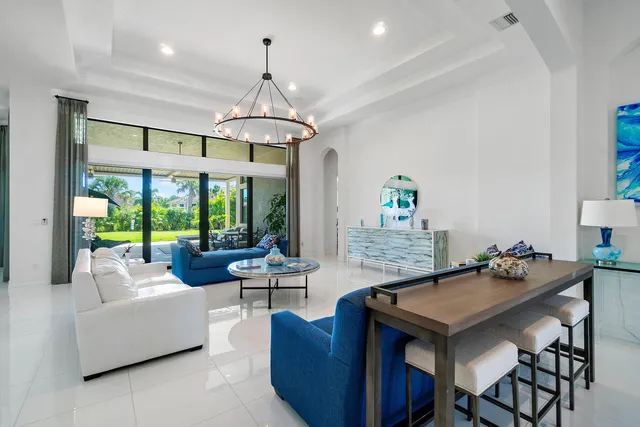 a living room with furniture a chandelier and a table