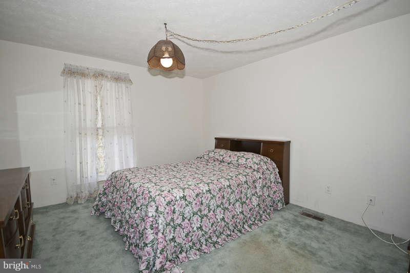 4715 Hawksbury Road Baltimore, MD 21208 - Photo 11 of 15 a bedroom with a bed and a chandelier