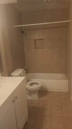 a bathroom with a granite countertop bathtub and toilet