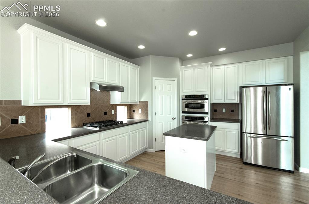 9443 St.George Road Peyton, CO 80831 - Photo 19 of 45 a kitchen with granite countertop a refrigerator and a sink