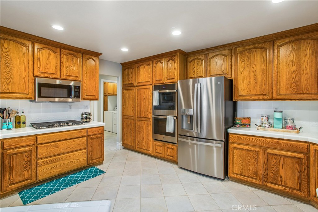31607 Florida Street Redlands, CA 92373 - Photo 14 of 65 a kitchen with stainless steel appliances granite countertop a refrigerator oven a sink dishwasher and wooden cabinets with large window