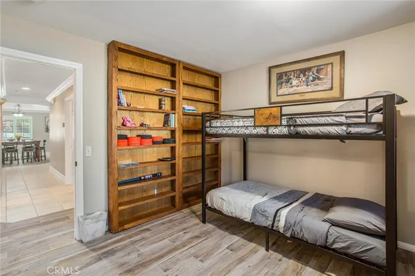 a bedroom with a bed a dresser and a chandelier