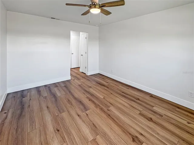 a view of an empty room with wooden floor