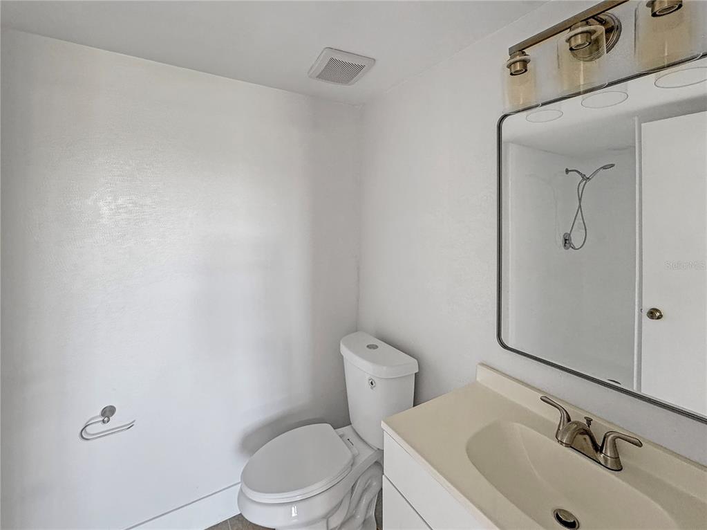 Undisclosed Address Seminole, FL 33777 - Photo 8 of 21 a bathroom with a toilet sink vanity and mirror