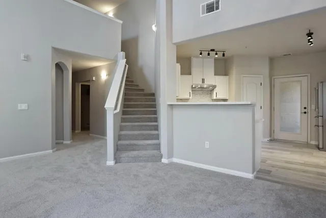 a kitchen with a refrigerator a sink and dishwasher with wooden floor