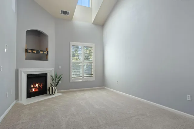 a white kitchen with granite countertop a stove a sink and white cabinets