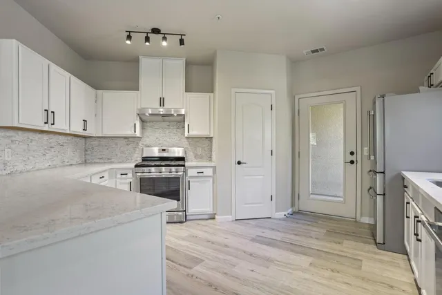 a kitchen with white cabinets and white stainless steel appliances