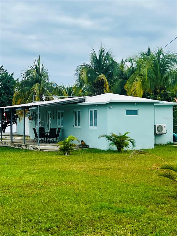 a view of a patio with table and chairs potted plants and large tree