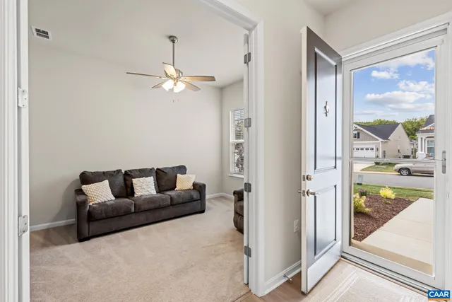 a living room with furniture and a floor to ceiling window
