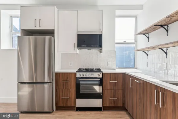 a kitchen with stainless steel appliances a refrigerator stove and microwave