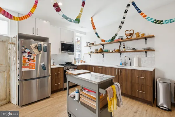 a kitchen with stainless steel appliances granite countertop a refrigerator and a stove