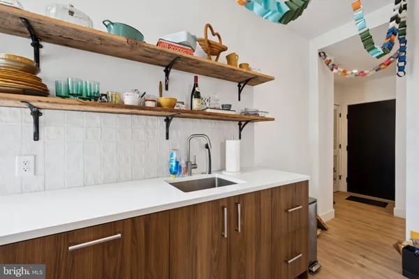 a kitchen with stainless steel appliances a microwave a refrigerator and wooden floor