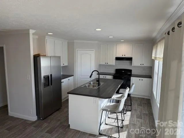 a kitchen with a refrigerator and a stove top oven