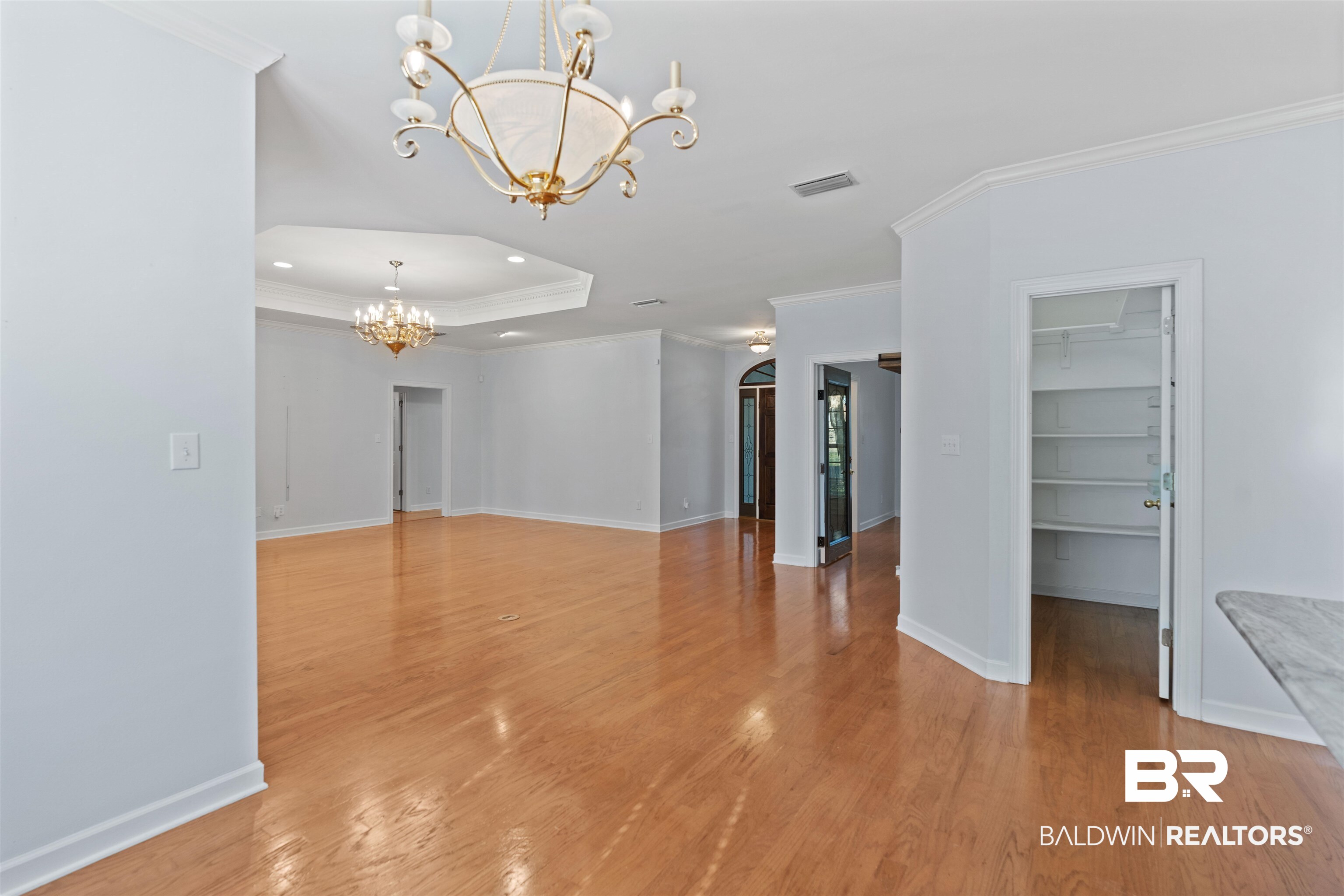 4 Judd Trail Daphne, AL 36527 - Photo 15 of 45 Unfurnished living room featuring ornamental molding, a notable chandelier, visible vents, and light wood-type flooring