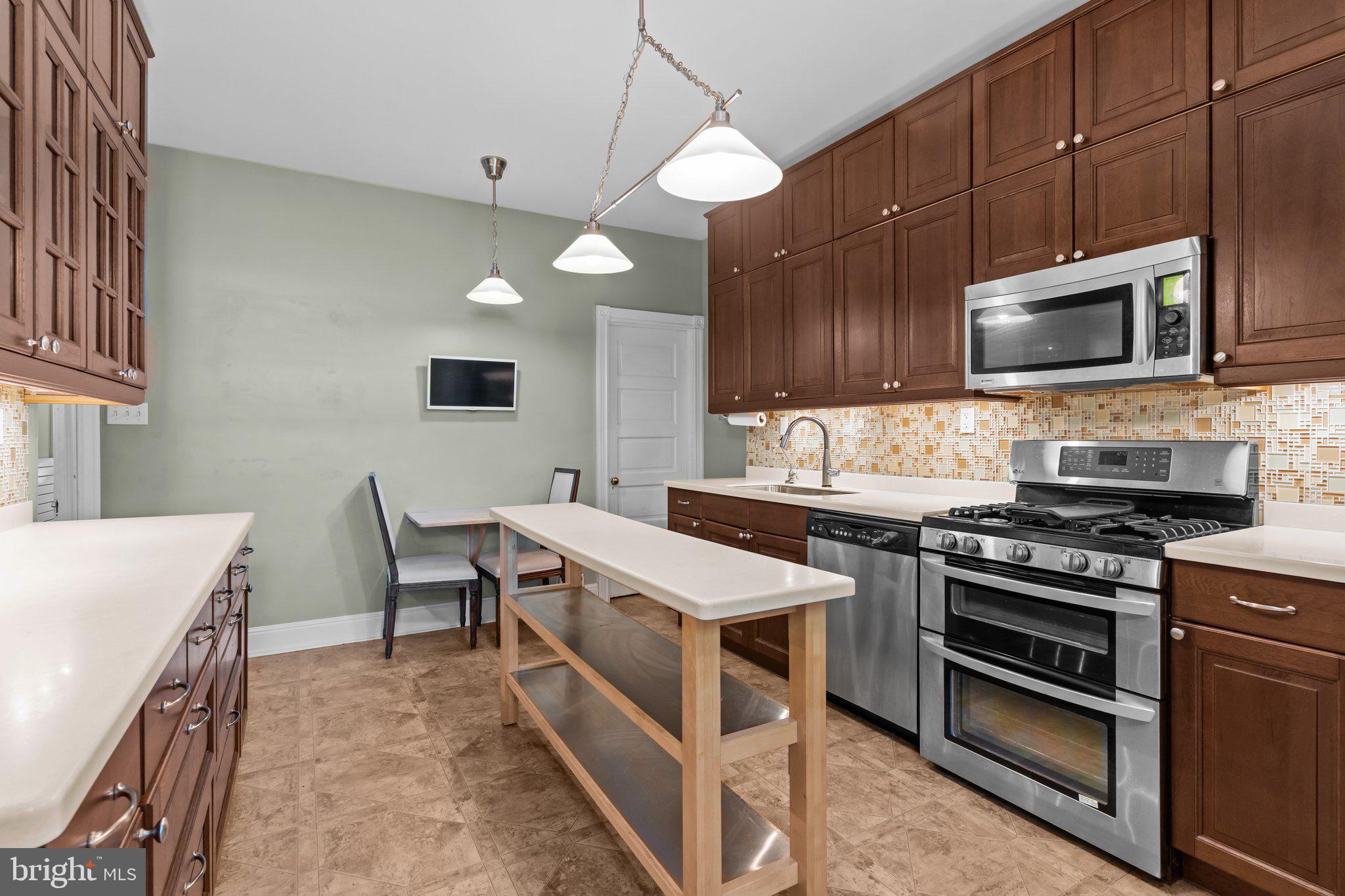 101 Cliff Terrace Wyncote, PA 19095 - Photo 8 of 21 a kitchen with stainless steel appliances a stove a sink a microwave a refrigerator and cabinets
