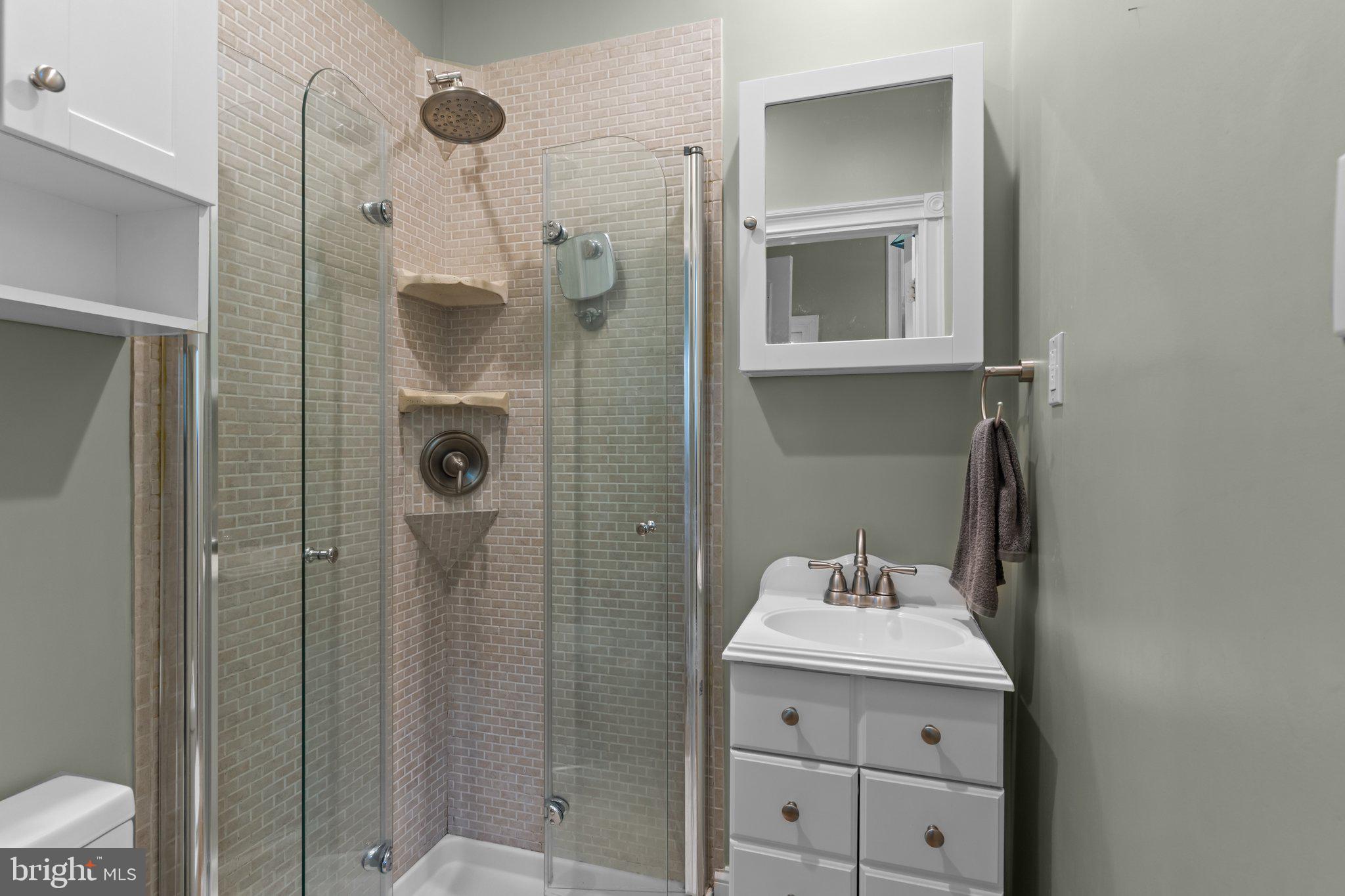 101 Cliff Terrace Wyncote, PA 19095 - Photo 9 of 21 a bathroom with a shower sink and mirror