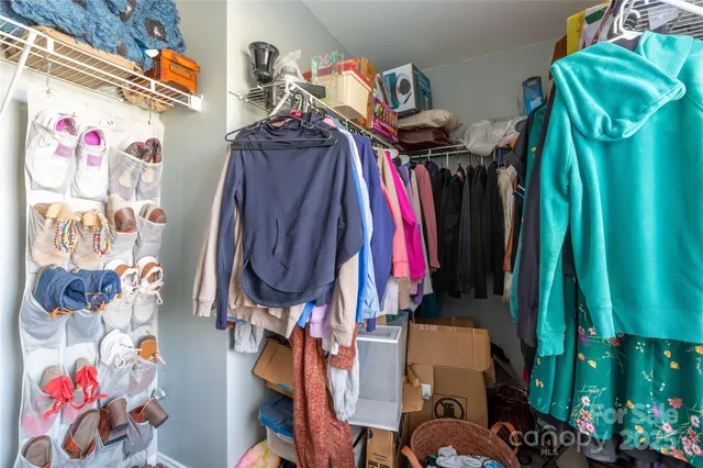 a view of walk in closet with clothes and shoes