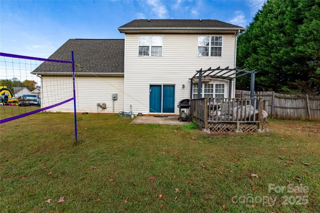 a white house that has a small yard and a wooden fence