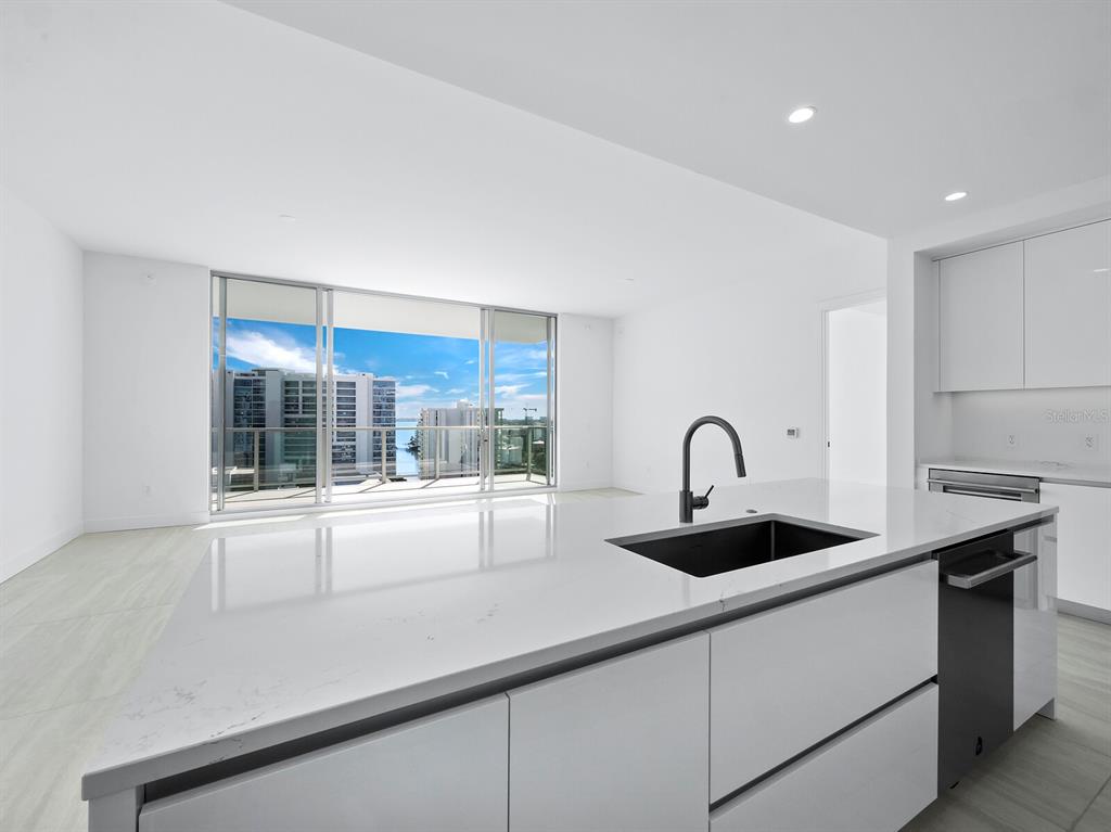 301 Quay Commons, Unit 1409 Sarasota, FL 34236 - Photo 11 of 45 a kitchen with stainless steel appliances granite countertop a sink and a stove next to a window
