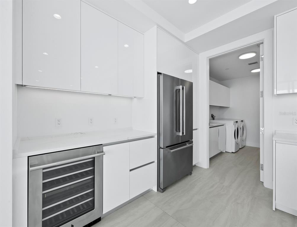301 Quay Commons, Unit 1409 Sarasota, FL 34236 - Photo 12 of 45 a kitchen with white cabinets and stainless steel appliances