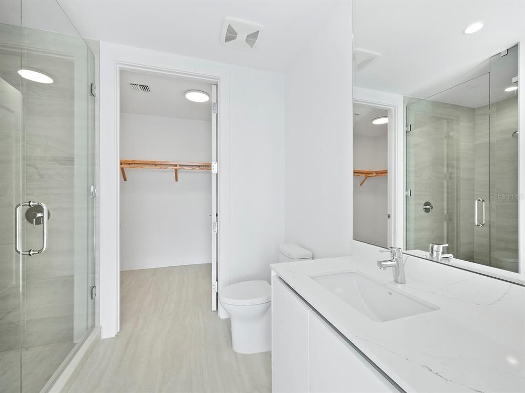 301 Quay Commons, Unit 1409 Sarasota, FL 34236 - Photo 15 of 45 a bathroom with a sink a toilet and shower