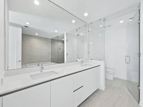 a bathroom with a double vanity sink mirror and toilet