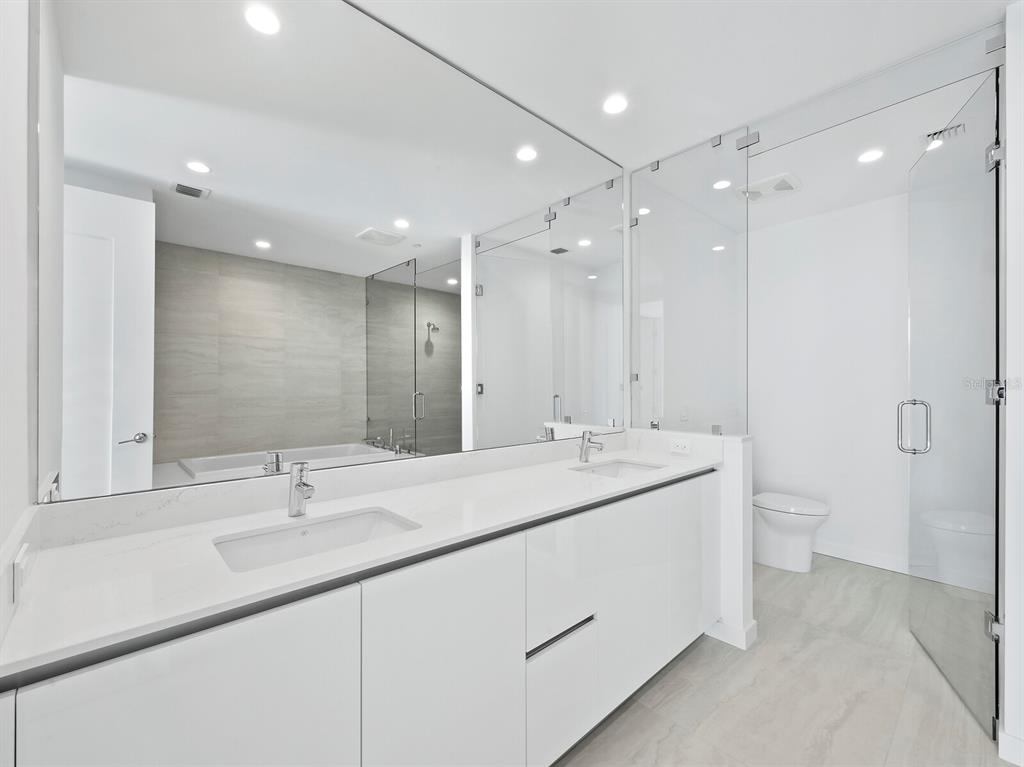 301 Quay Commons, Unit 1409 Sarasota, FL 34236 - Photo 16 of 45 a bathroom with a double vanity sink mirror and toilet