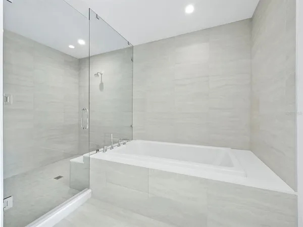 a white bath tub sitting next to a shower