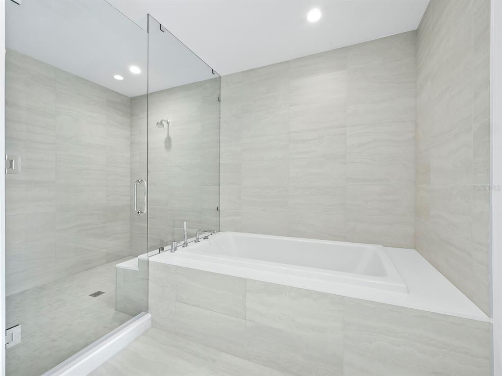 301 Quay Commons, Unit 1409 Sarasota, FL 34236 - Photo 17 of 45 a white bath tub sitting next to a shower