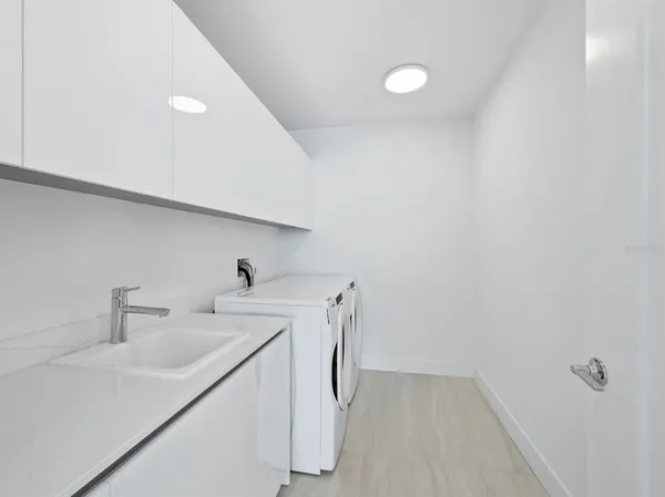 a utility room with sink dryer and washer