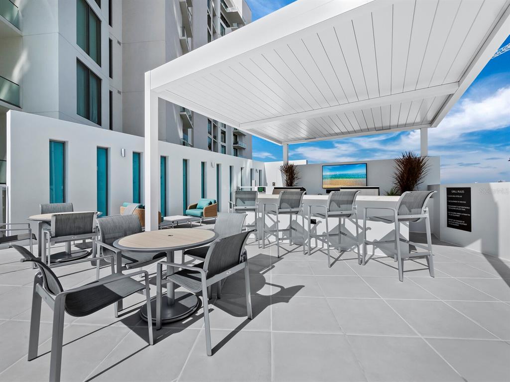 301 Quay Commons, Unit 1409 Sarasota, FL 34236 - Photo 35 of 45 a view of a patio with table and chairs and potted plants