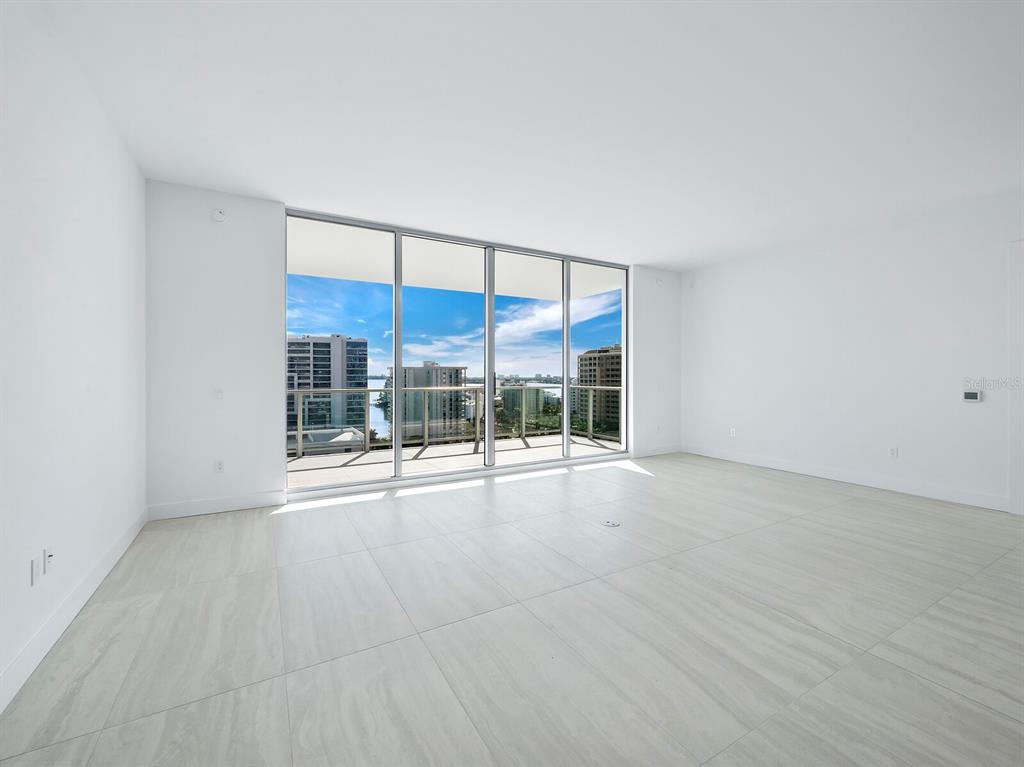 301 Quay Commons, Unit 1409 Sarasota, FL 34236 - Photo 4 of 45 an empty room with floor to ceiling window and an outdoor view