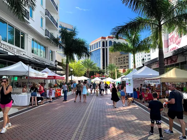 a group of people sitting in front of retail shops