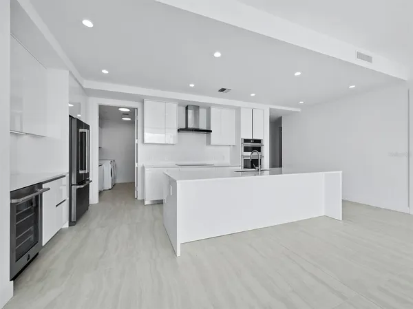 a large kitchen with stainless steel appliances a large counter top and a stove top oven