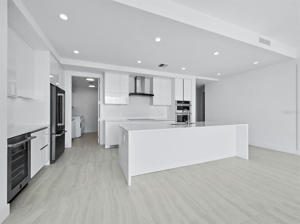 301 Quay Commons, Unit 1409 Sarasota, FL 34236 - Photo 10 of 45 a large kitchen with stainless steel appliances a large counter top and a stove top oven