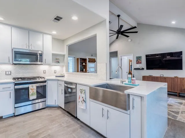 a kitchen with granite countertop a sink and stainless steel appliances